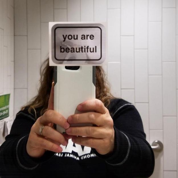 Sticker taped to mirror in Gender Neutral bathroom